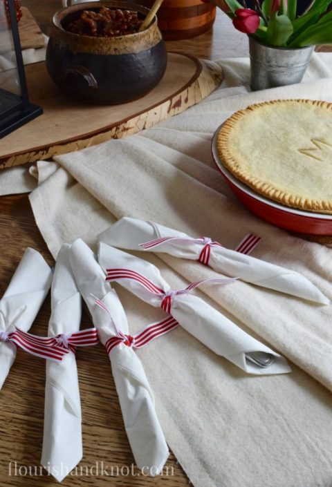 Napkins tied with red and white striped ribbons | Tourtiere (meat pie) | Sugar Shack Lunch | Cabane a sucre menu | A Year of Feasting - Spring | Traditional Canadian Quebec meal