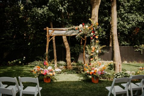 Colourful chuppah with fall planters and greenery and flowers climbing up chuppah | Photography by L'Orangerie Photographie | Foam-free floral installation by Flourish & Knot | Foam-free floral installation | Dahlias, zinnias, roses