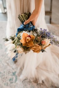 Bridal bouquet in terracotta and blue with long trailing ribbons | Boho wedding style | Mariage au Verger du Flanc Nord