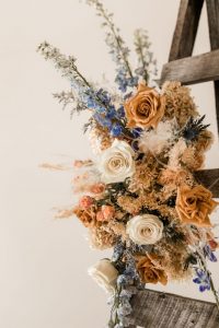 Foam-free floral installation for wedding arch or ceremony in terracotta and blue palette | Flourish & Knot