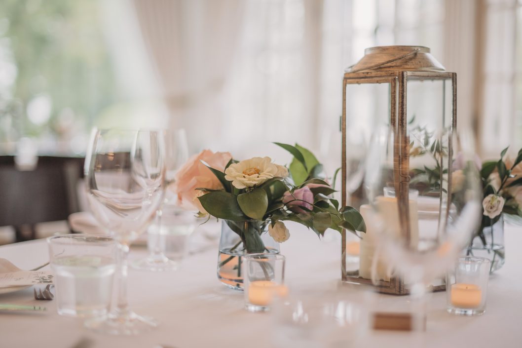 Blue glass bud vase centrepiece with peach and coral flowers and lanterns | Auberge Willow Inn | Lindsay Muciy