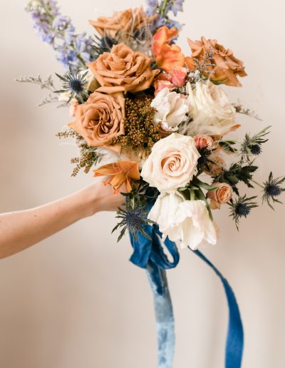 Bridal bouquet of roses and delphinium in blue and terracotta palette with silk velvet ribbon | Kerstin Hahn Photography | Flourish & Knot