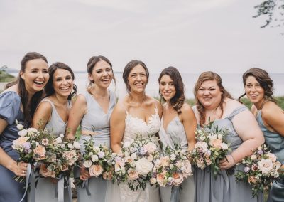 Bride and bridesmaids in dusty blue with peach and coral bouquets | Auberge Willow Inn