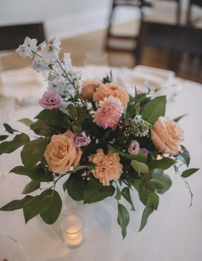 Peach and pale blue compote centrepiece with roses and delphinium