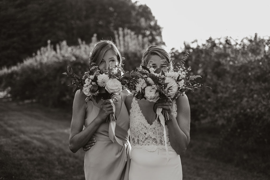 Bride and bridesmaid playing with bouquets