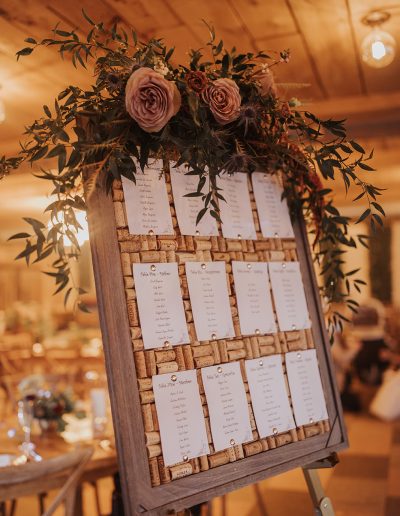 Wedding seating chart with lush floral swag with amnesia roses and grapes