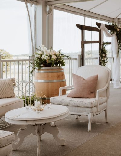 Open-air cocktail lounge with blush accents and flowers on wine barrel | Au jardin d'Emmanuel wedding | Flourish & Knot
