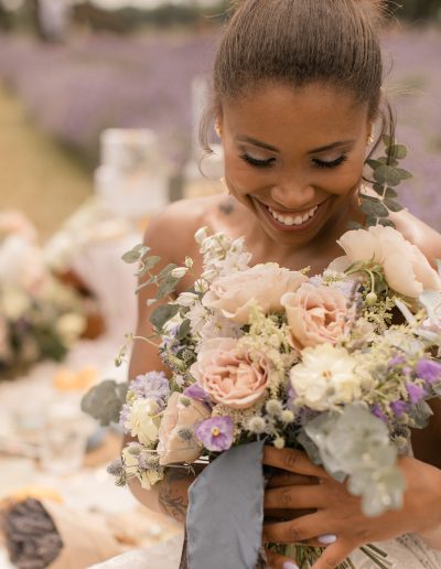 Bride looking down at romantic bridal bouquet with garden roses and eucalyptus