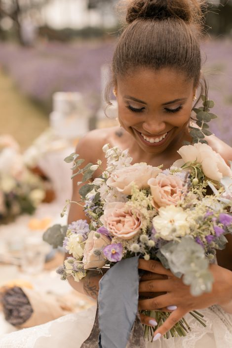 Bride looking down at romantic bridal bouquet with garden roses and eucalyptus