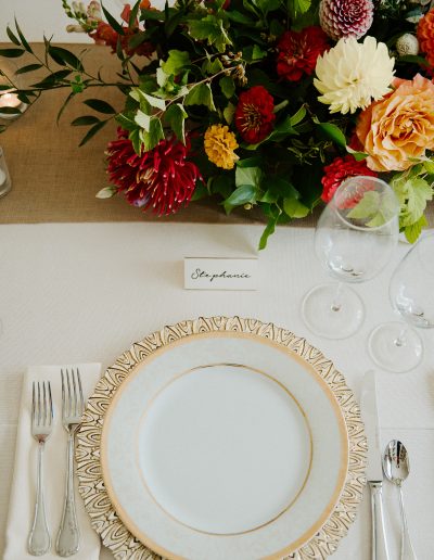 Elegant gold and white place setting with lush summer flowers