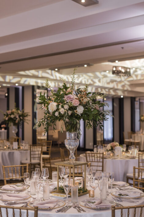 Elegant tall wedding centerpiece in glass vase with roses and draping foliages | Elegant ballroom wedding | Flourish & Knot | Montreal wedding florist | Hotel Place D'Armes wedding | Montreal Old Port Wedding