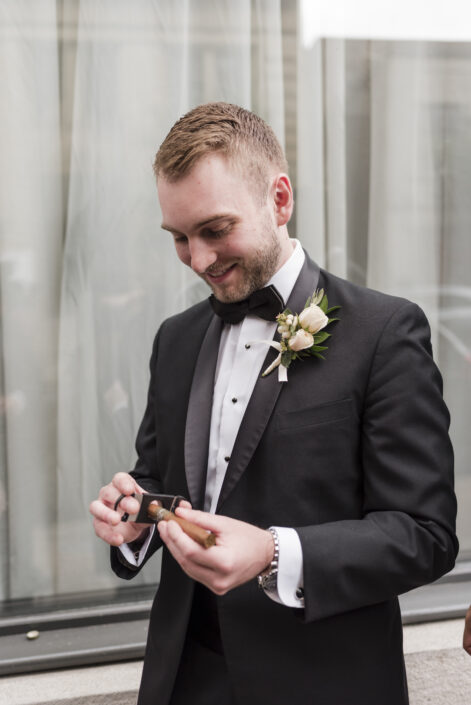 Groom with classic boutonniere of off-white spray roses, snowberry and olive foliage | Flourish & Knot | Montreal wedding florist | Hotel Place D'Armes wedding | Montreal Old Port Wedding