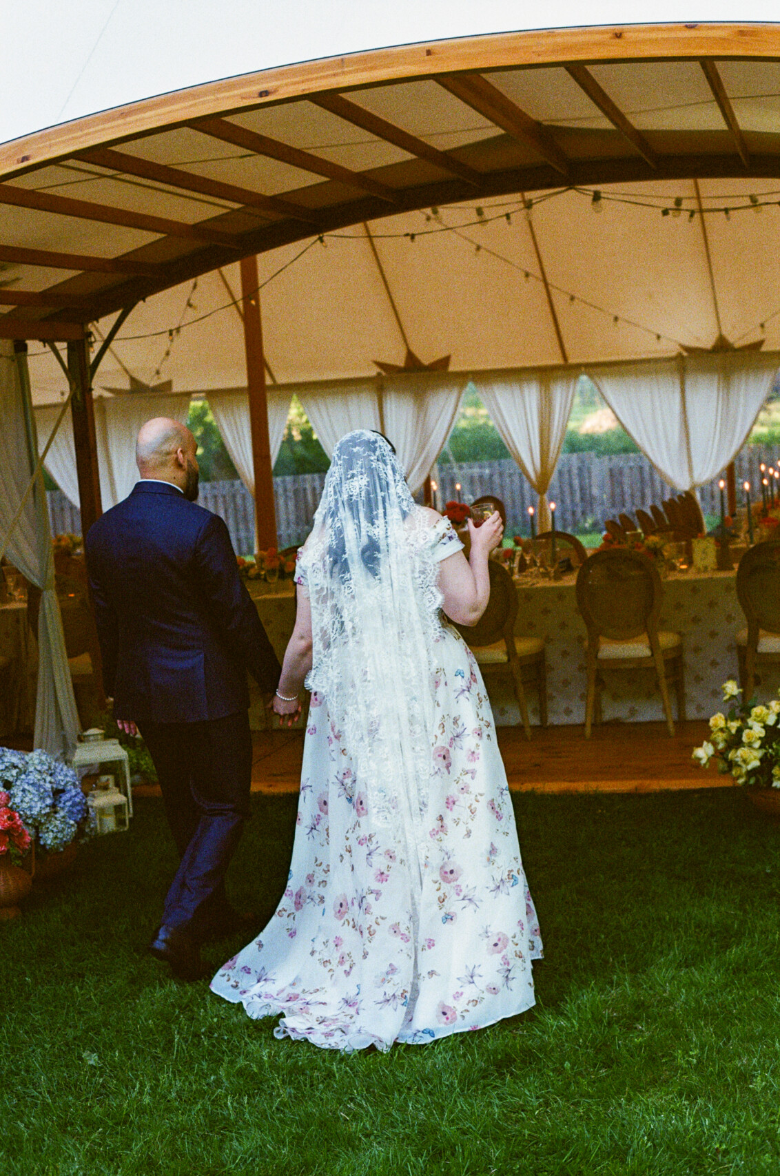 Bride and groom entering a luxury sailcloth wedding tent featuring bespoke romantic event design on a private historic estate in the Eastern Townships by Flourish and Knot